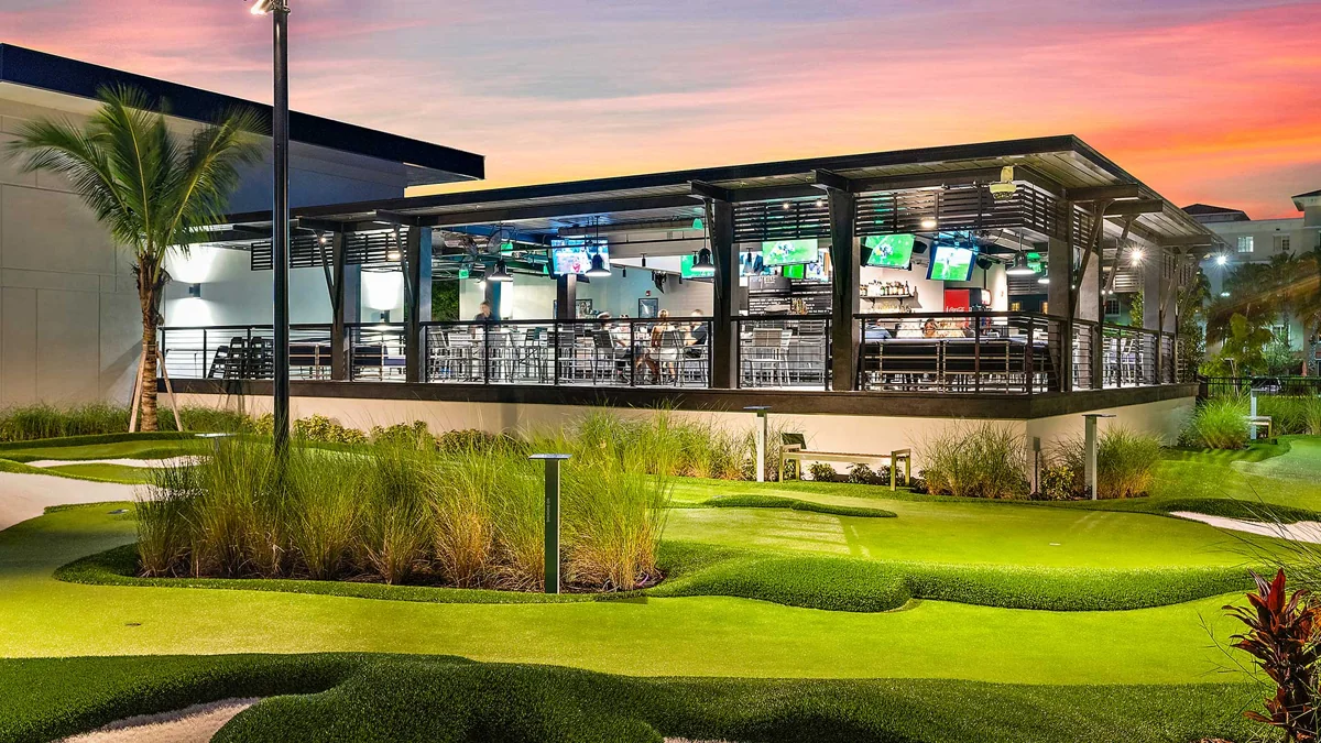 Putting greens and outdoor dining at PopStroke Port St. Lucie at sunset